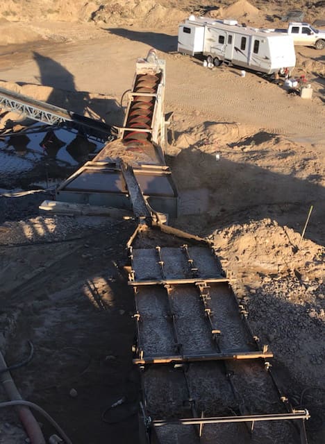 Gravity concentrate running over sluice mats — the same separation principle the 1980s circuits used at industrial scale.