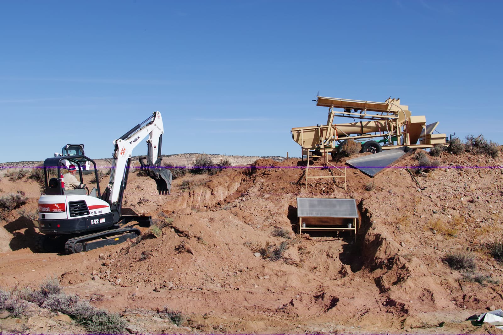 Test excavation into the terrace gravels — the same ground the early examiners sampled by hand.